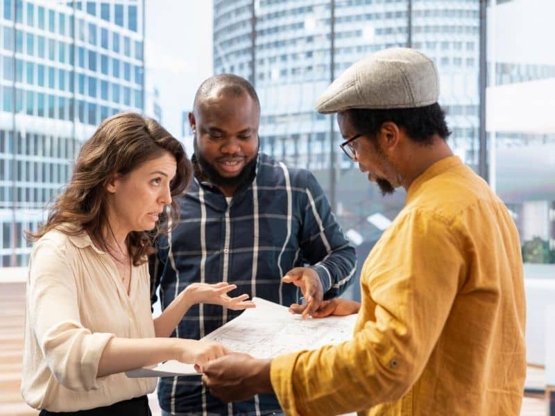 Professionals reviewing documents related to an ALTA survey for a commercial property purchase